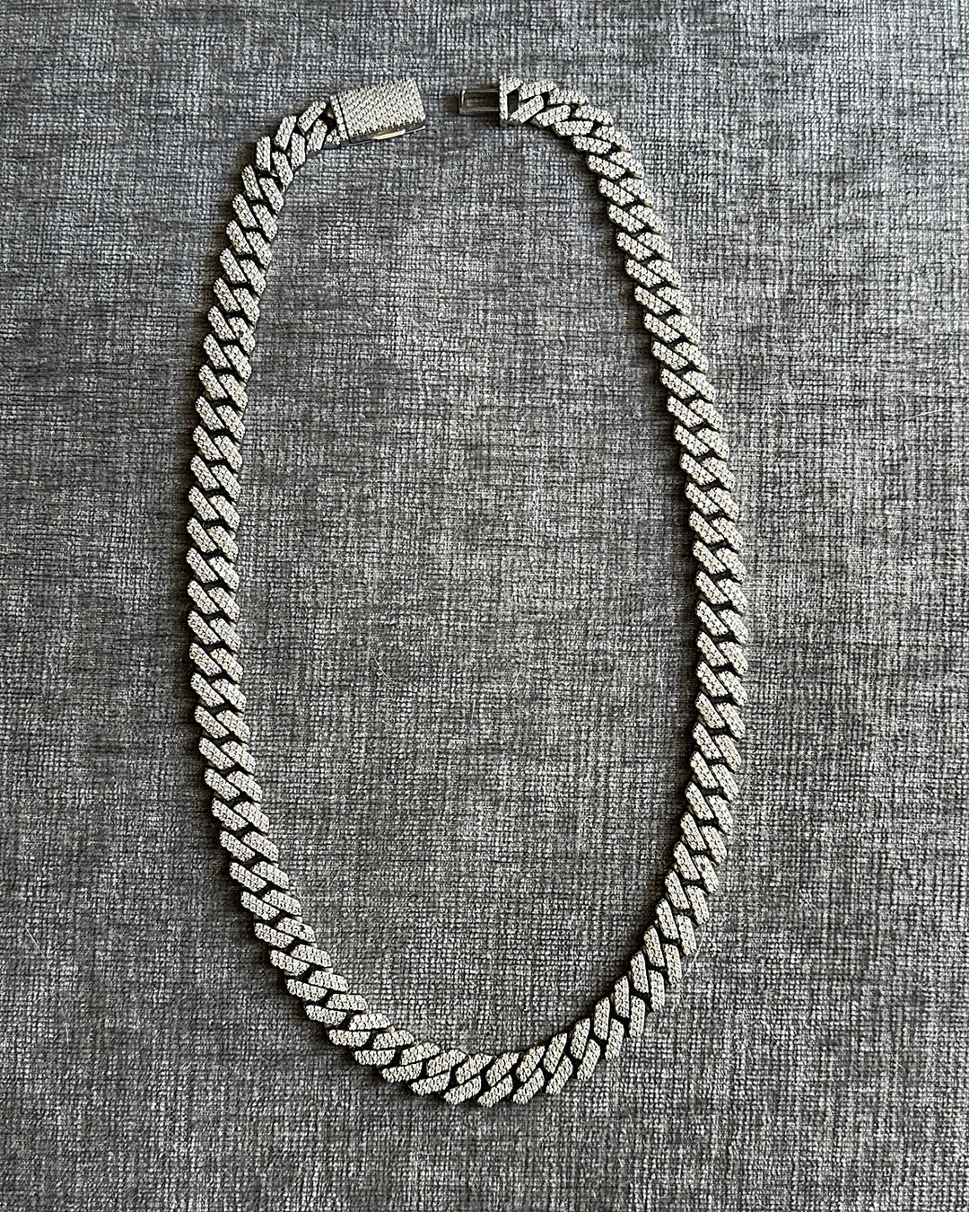 Silver chain necklace on a textured gray background