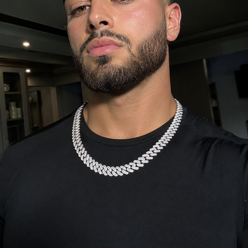 Man wearing a black shirt and silver chain necklace indoors