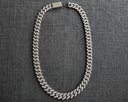 Silver chain necklace on a textured gray background
